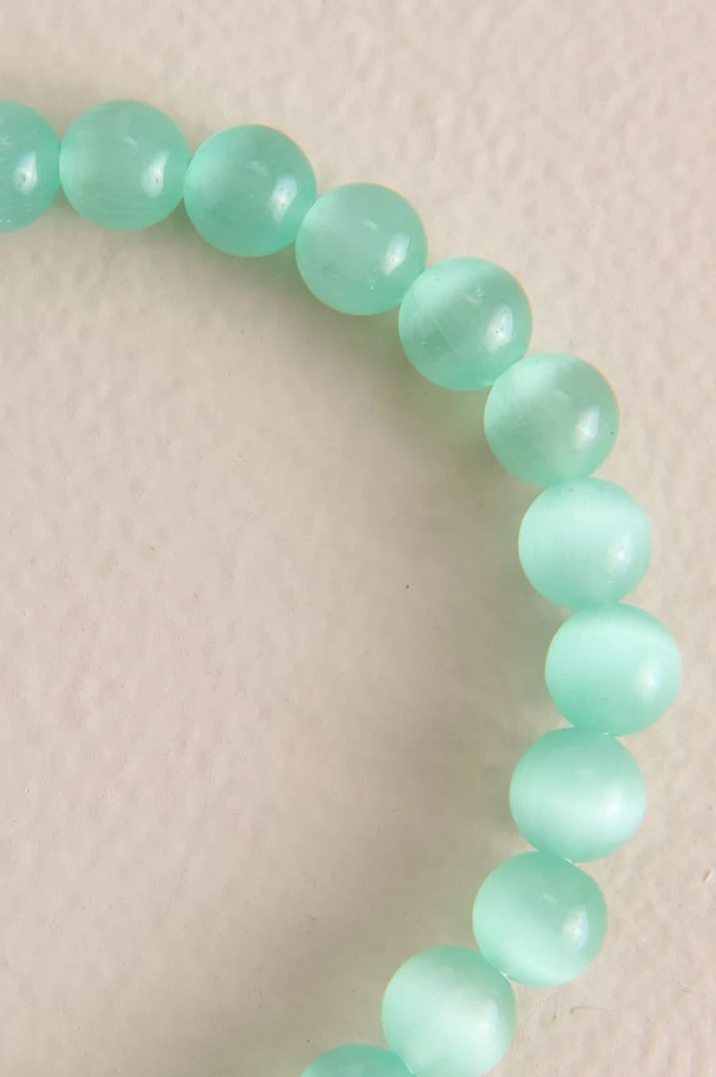 Pastel Green Cat's Eye Beaded Bracelet is a shimmering shining two toned accent piece that would upgrade any whimsical outfit