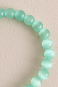 Pastel Green Cat's Eye Beaded Bracelet is a shimmering shining two toned accent piece that would upgrade any whimsical outfit