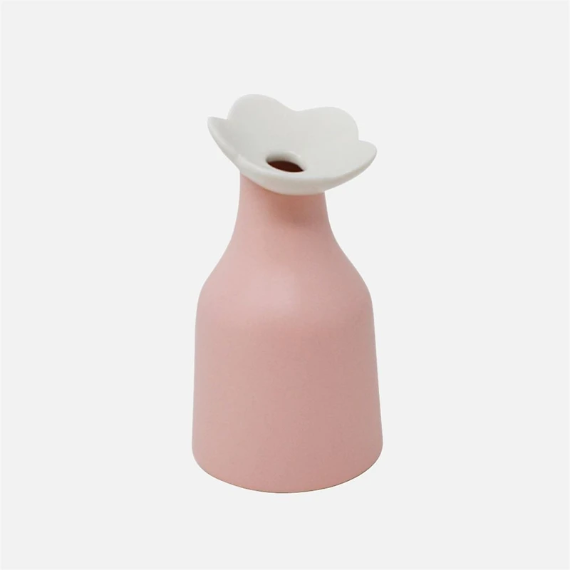 Vase rose avec une fleur blanche