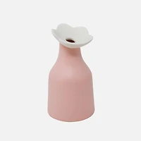 Vase rose avec une fleur blanche