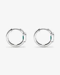 Création des boucles d’oreilles Huggie en lunette émeraude en or blanc 10 carats