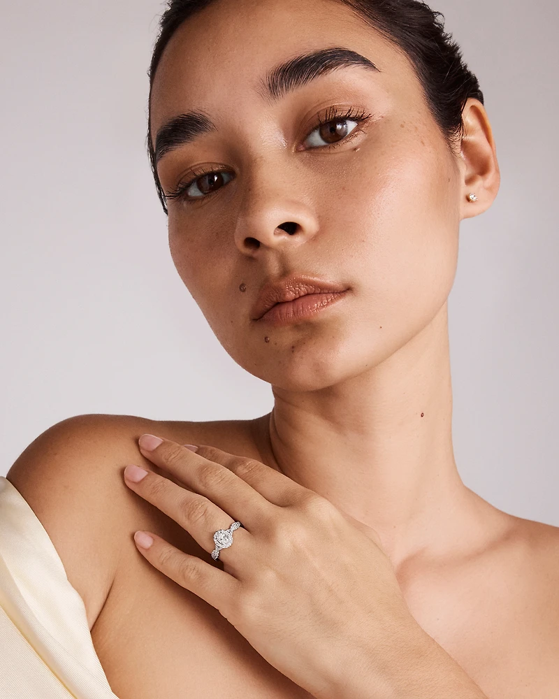 0.75 Carat TW Oval Cut Diamond Twist Side Accent Halo Engagement Ring in 14kt White Gold