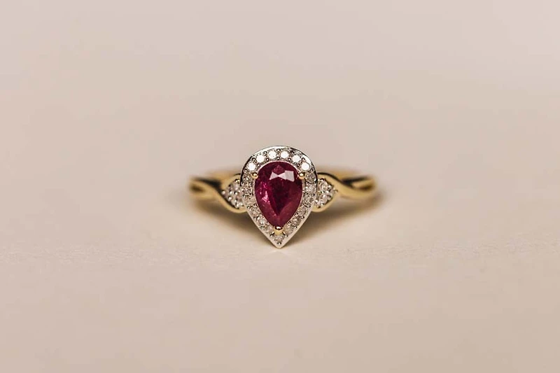 Halo Ring with .17 Carat TW of Diamonds and 7x5MM Pear Shape Ruby in 10kt Yellow Gold