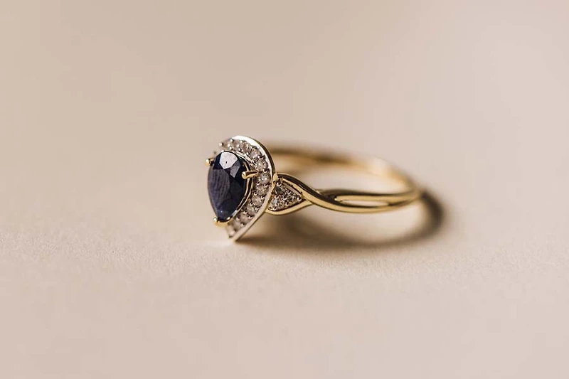 Halo Ring with .17 Carat TW of Diamonds and 7x5MM Pear Shape Blue Sapphire in 10kt Yellow Gold