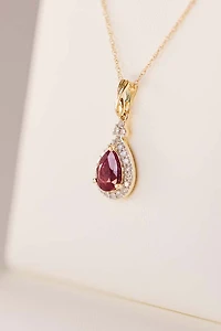 Halo Pendant with .13 Carat TW of Diamonds and 7x5MM Pear Shape Ruby in 10kt Yellow Gold with Chain