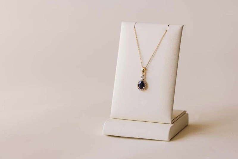 Halo Pendant with .13 Carat TW of Diamonds and 7x5MM Pear Shape Blue Sapphire in 10kt Yellow Gold with Chain