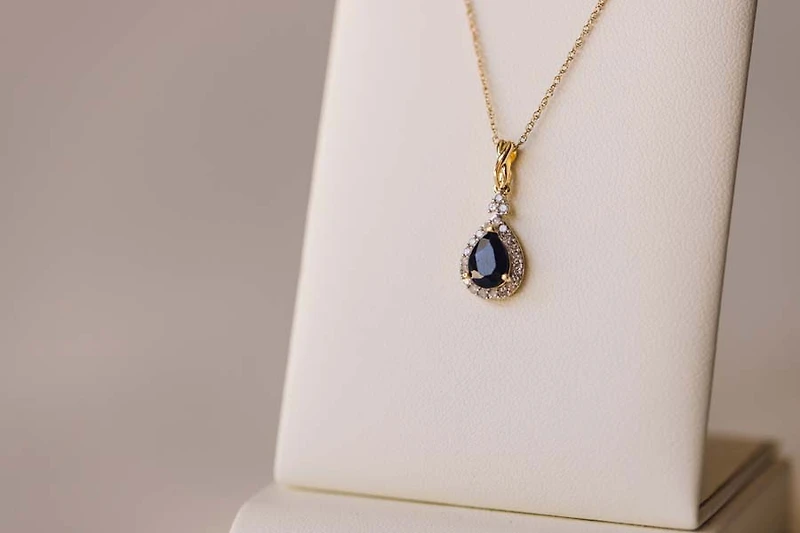Halo Pendant with .13 Carat TW of Diamonds and 7x5MM Pear Shape Blue Sapphire in 10kt Yellow Gold with Chain