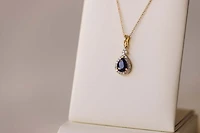 Halo Pendant with .13 Carat TW of Diamonds and 7x5MM Pear Shape Blue Sapphire in 10kt Yellow Gold with Chain