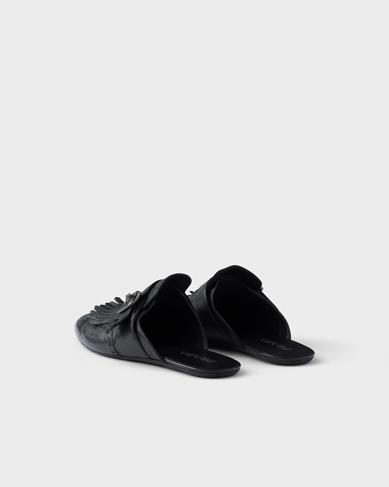 Shuffle antiqued leather mules with buckled strap and fringe