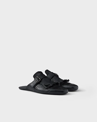 Shuffle antiqued leather mules with buckled strap and fringe