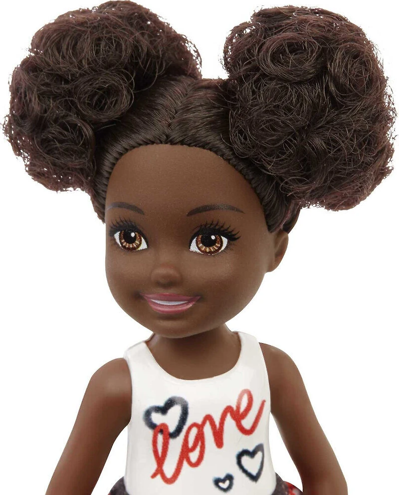 Poupée ​Barbie Chelsea, brunette, vêtue d'une jupe à imprimé coeurs et de chaussures métalliques