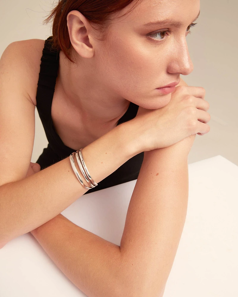 Pulsera rígida triple con curvas bañada en plata de ley
