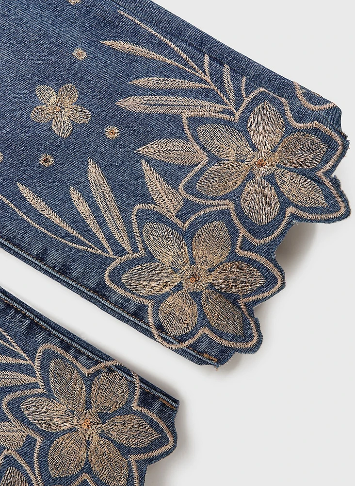 Jean à ourlet festonné et broderies dorées