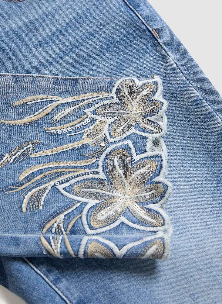 Jean à jambe droite et broderies