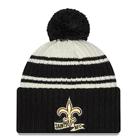 Youth New Era Cream/Black New Orleans Saints 2022 Sideline - Sport Cuffed Pom Knit Hat