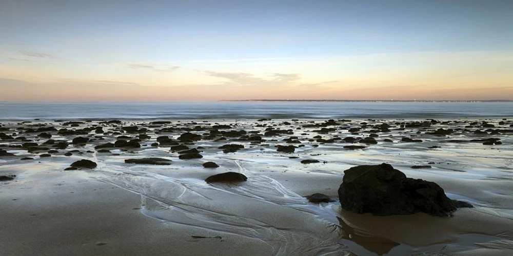 Ted Ray - Sunset over Beach with Rocks