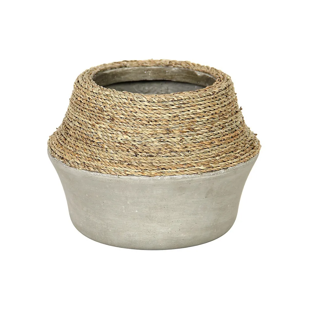 Pot de béton en forme de bidon avec herbe