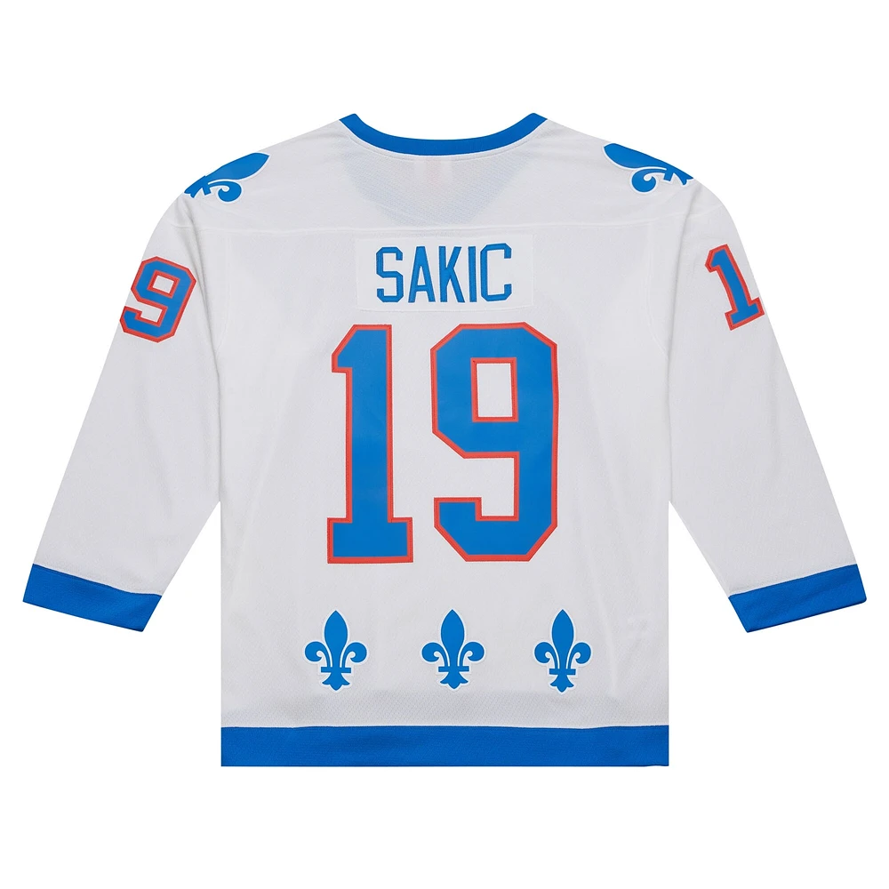 Maillot de joueur la ligne bleue Mitchell & Ness Joe Sakic, blanc, Patch du capitaine des Nordiques Québec 1994/95 pour hommes