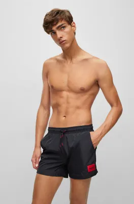 Quick-dry swim shorts with red logo label