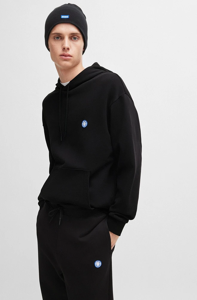 Cotton-terry tracksuit bottoms with smiley-face logo patch