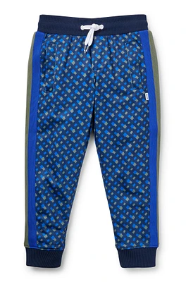 BOSS - Kids' tracksuit bottoms with printed monograms and side stripes Dark Blue