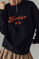 KULE The Oversized Brooklyn Graphic Sweatshirt