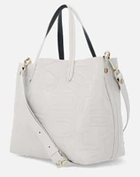 Bolso tipo tote mediano en piel grabada de letras descompuestas Prada en color beige