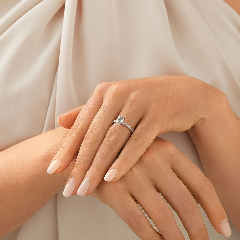 Bague de fiançailles avec diamants totalisant 1,14 ct  en or blanc 14 K. Ornée d'un diamant ovale de 1 ct créé en laboratoire en son centre, accompagné de diamants naturels totalisant 0,14 ct.