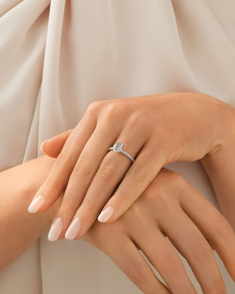 Bague de fiançailles avec diamants totalisant 1,14 ct  en or blanc 14 K. Ornée d'un diamant ovale de 1 ct créé en laboratoire en son centre, accompagné de diamants naturels totalisant 0,14 ct.