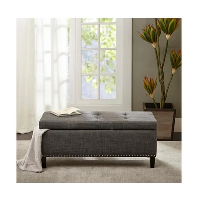 Modern tufted storage bench with soft-close lid, grey linen upholstery, button tufting, black wood legs, and interior for bedroom or entryway.