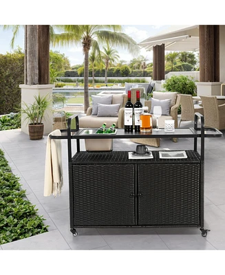 Black wicker outdoor bar cart with steel top, ice bucket, locking wheels, and side basket