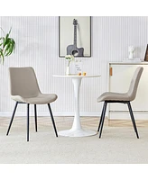 Light gray artificial leather backrest cushion dining chair, black metal legs, curved widened cushion design for more comfort, suitable for restaurant