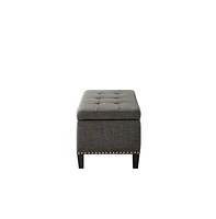 Modern tufted storage bench with soft-close lid, grey linen upholstery, button tufting, black wood legs, and interior for bedroom or entryway.