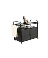 Black wicker outdoor bar cart with steel top, ice bucket, locking wheels, and side basket
