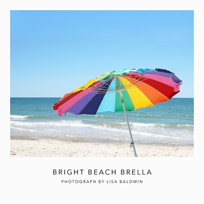 Photo of Bright Beach Umbrella with Colorful Stripes Fluttering in the Ocean Breeze