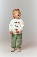 PULL EN MAILLE AVEC INSCRIPTION BRODÉE