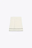MINI JUPE EN MAILLE À SURPIQÛRES