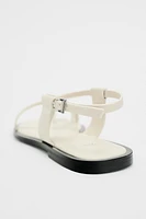 FLAT STRAPPY SANDALS WITH METAL ORNAMENT