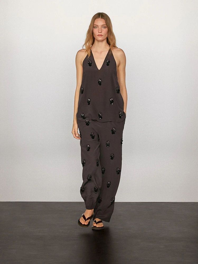 Flowing trousers with floral appliqués