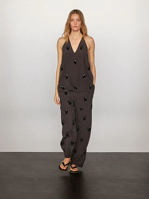 Flowing trousers with floral appliqués