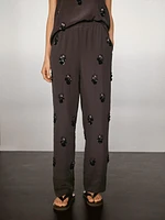 Flowing trousers with floral appliqués