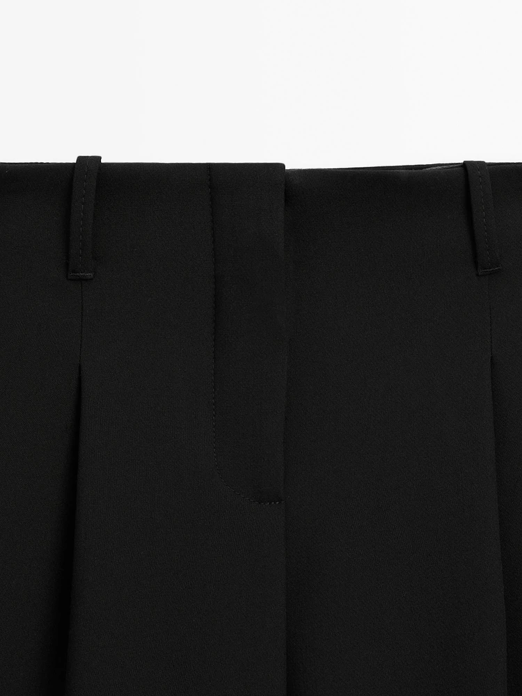 Flowing mid-waist trousers with buckles