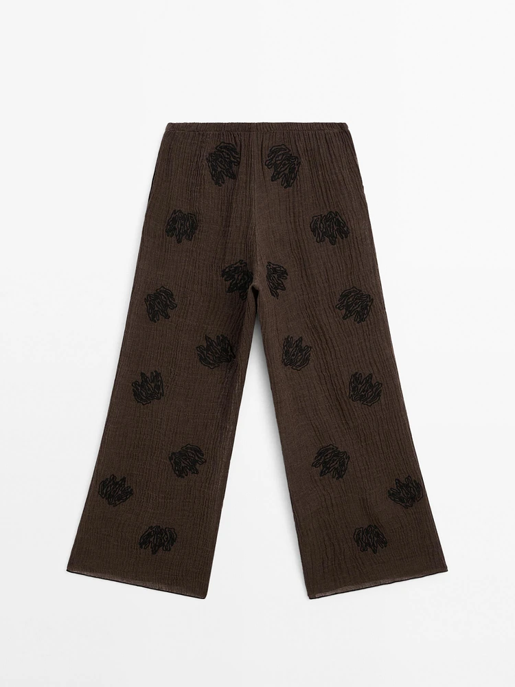 Flowing textured trousers with embroidered detail