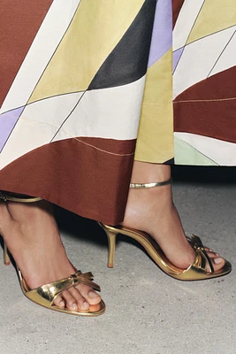 METALLIC EFFECT BOW HEELED SANDALS