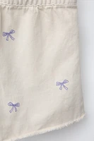 EMBROIDERED BOW TWILL SHORT JUMPSUIT