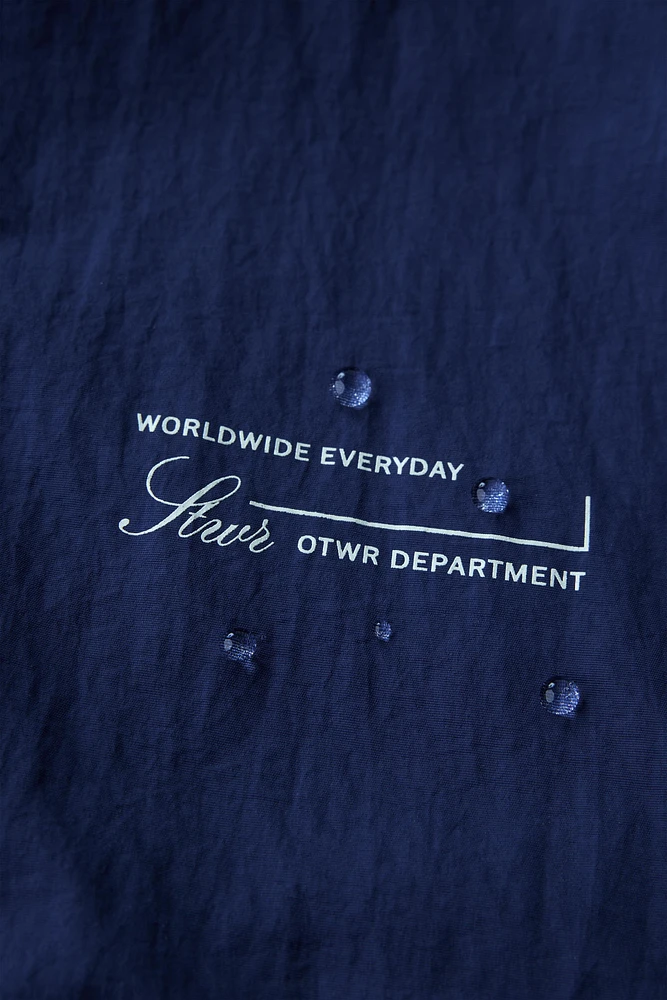 WATER REPELLENT TEXT PRINT HOODED RAINCOAT
