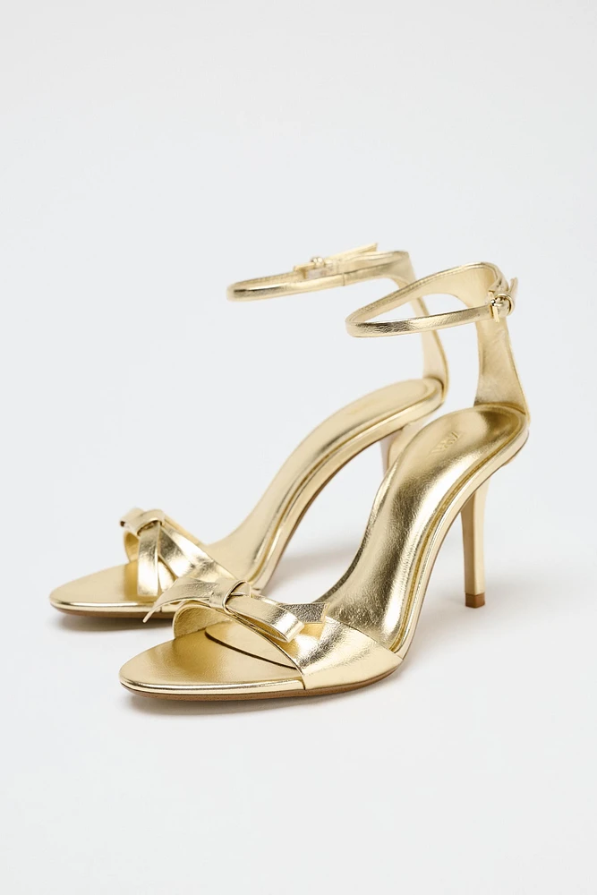 METALLIC EFFECT BOW HEELED SANDALS