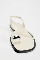 FLAT STRAPPY SANDALS WITH METAL ORNAMENT