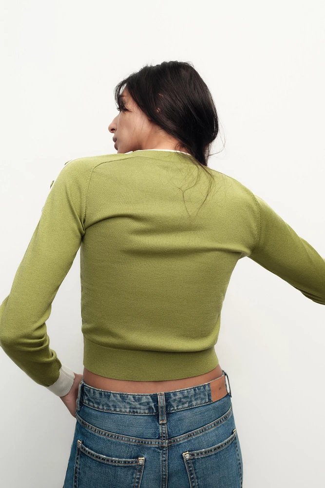 PULL À BOUTONS AUX ÉPAULES