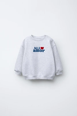 “ALL AMOR” FLOCKED TEXT SWEATSHIRT